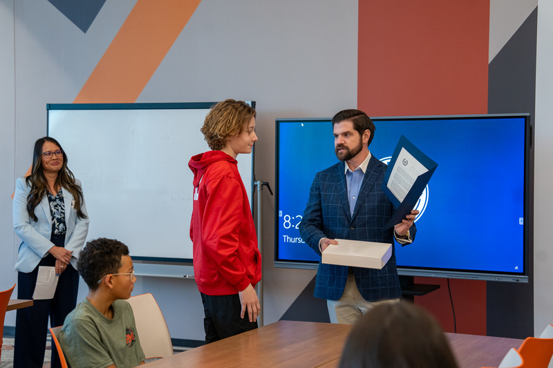 man and teen boy in classroom talking