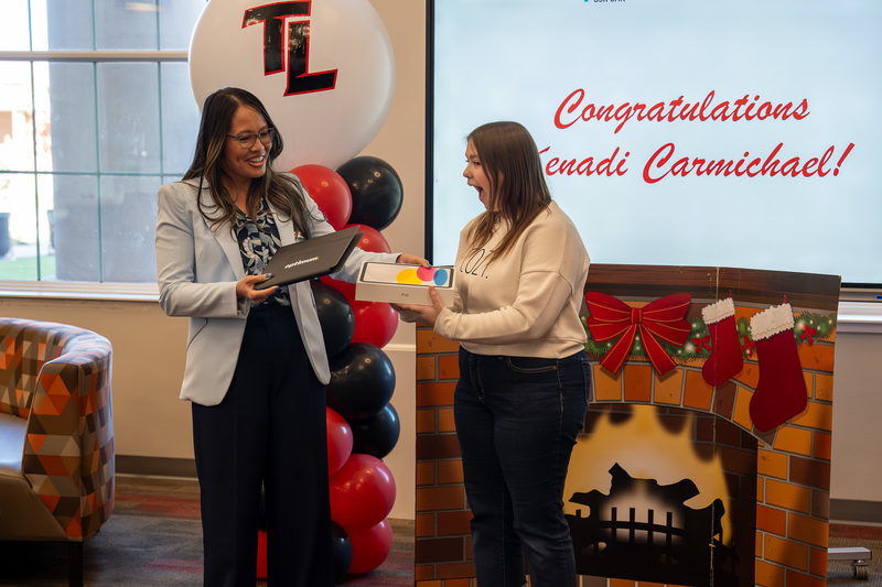 woman handing teen girl ipad and teen girl excited