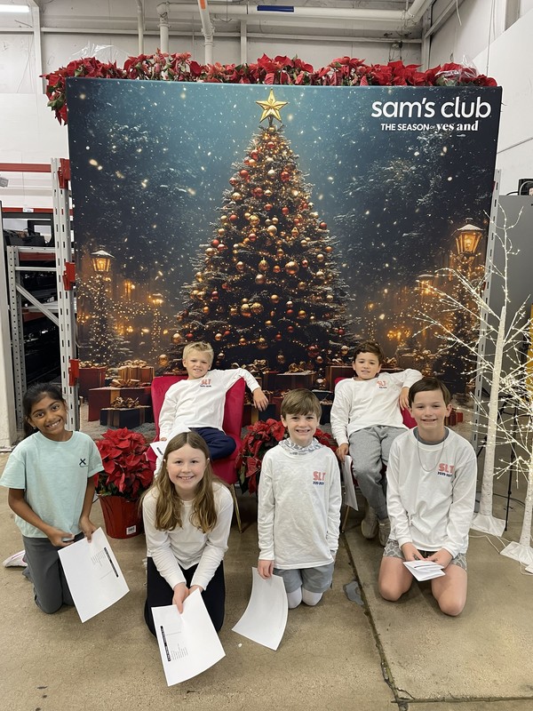 elementary kids in front of Christmas tree