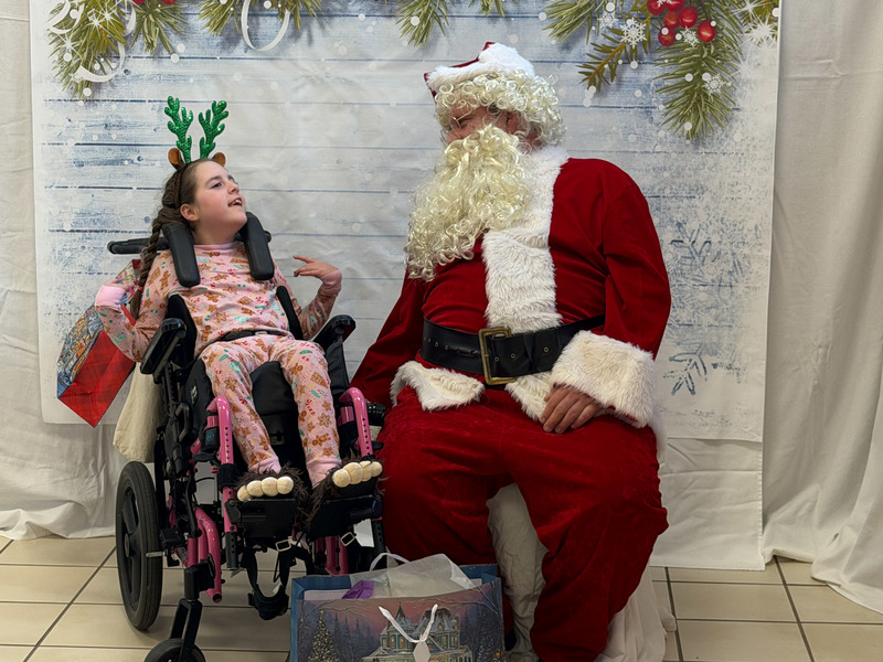 young girl in wheelchair talking to Santa