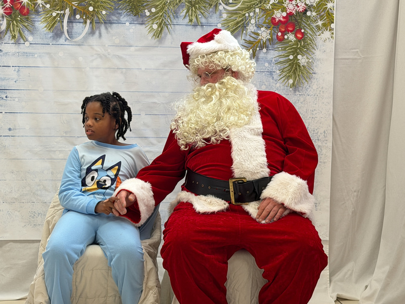 young girl holding Santa's hand