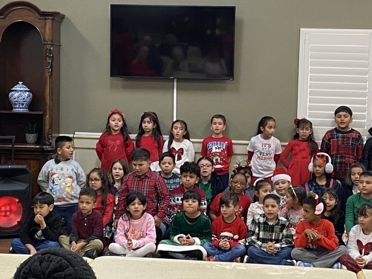elementary age kids in Christmas outfits singing