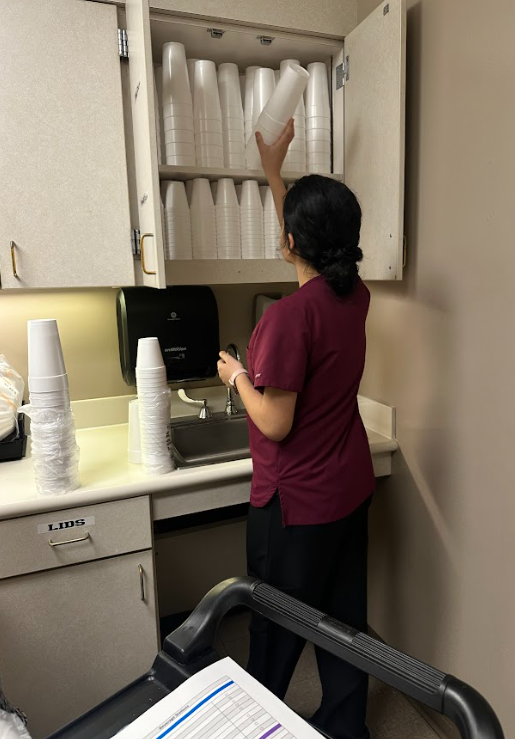 teen girl packing cups in cabinet