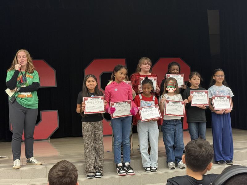 students standin on the stage with mrs. cureton our principal 