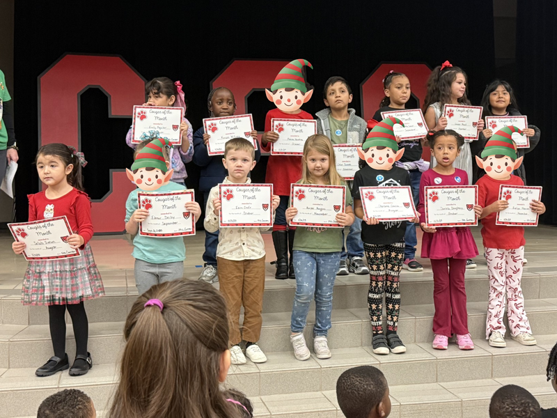 students standin on the stage with mrs. cureton our principal 