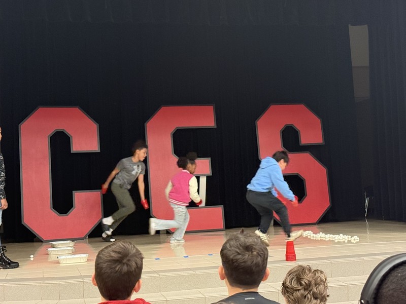 students standin on the stage with mrs. cureton our principal 