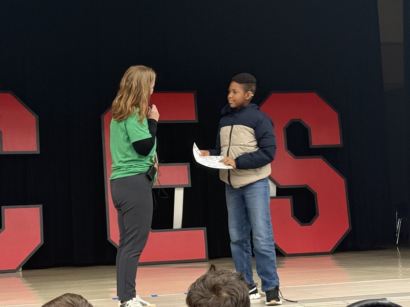 students standin on the stage with mrs. cureton our principal 