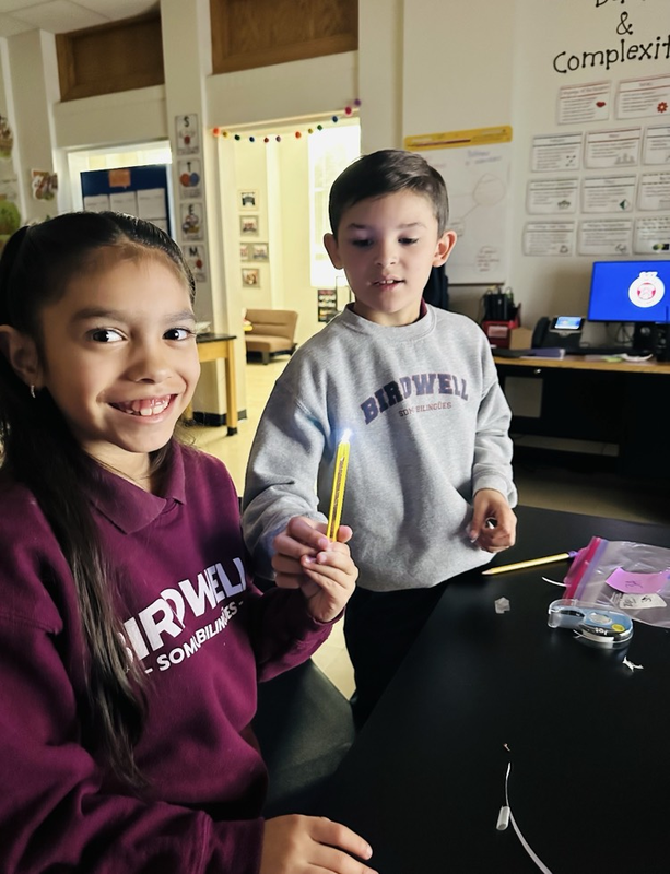girl and boy holding pencils