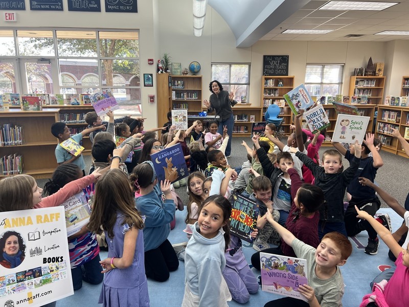 Students with anna raff holding the books she has illustrated