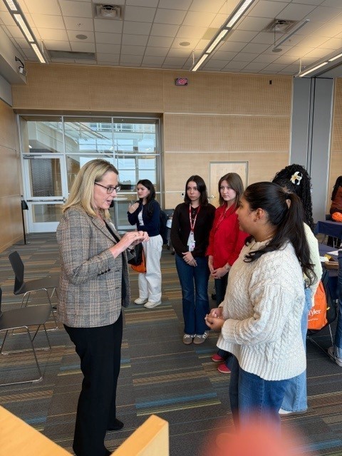 woman talking to group of teens