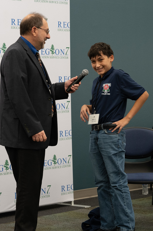 man holding microphone for young boy