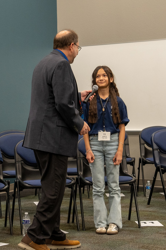 man holding microphone for young girl