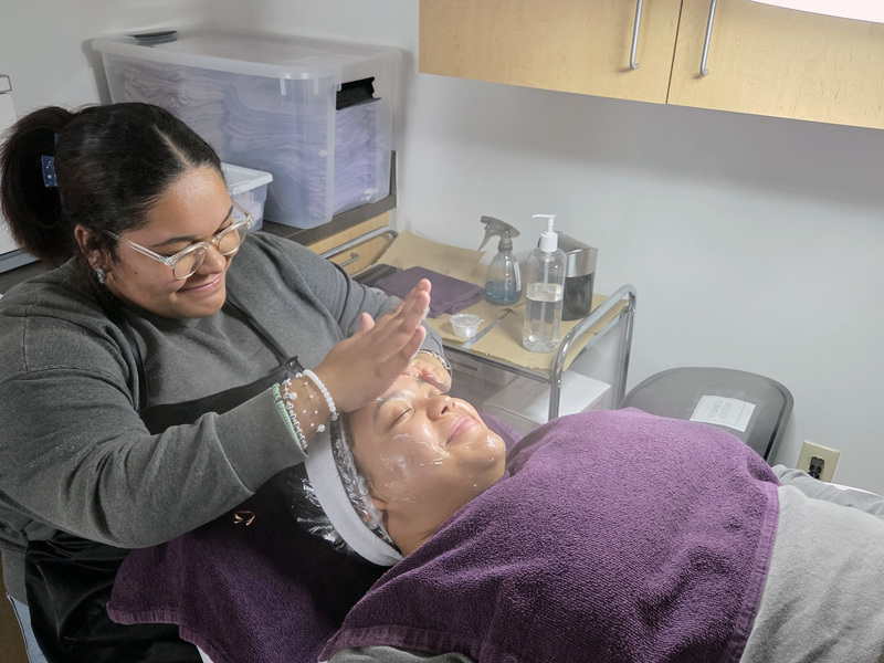 teen girl giving woman a facial