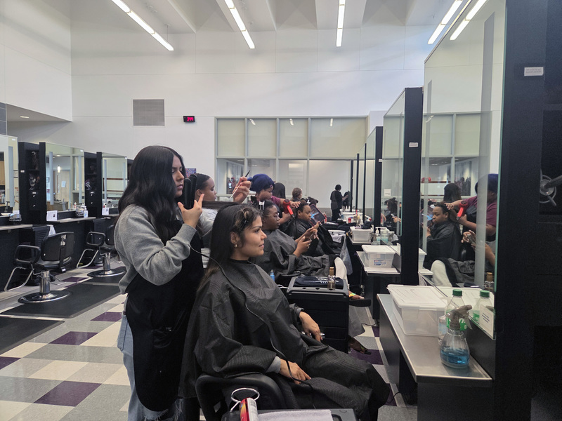 teen girls styling women's hair in salon