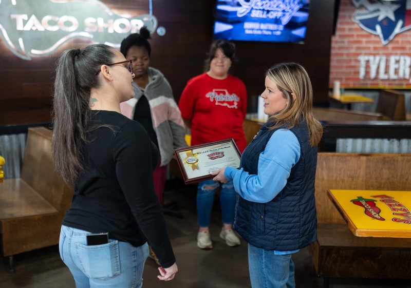 woman presenting certificate to another woman