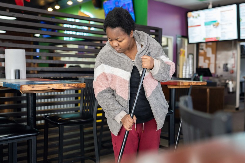 teen girl sweeping floor