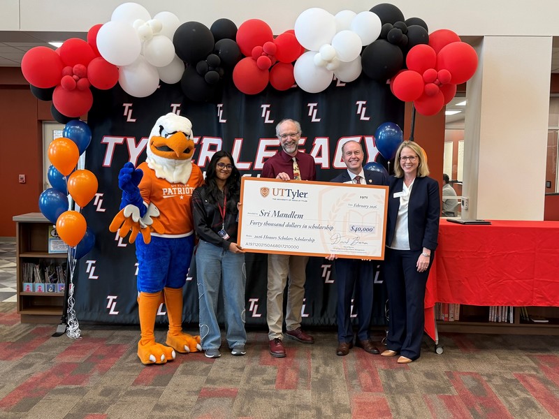 Eagle mascot, two men and two women holding giant check