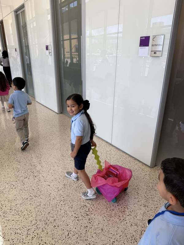 young girl pulling wagon down hallway