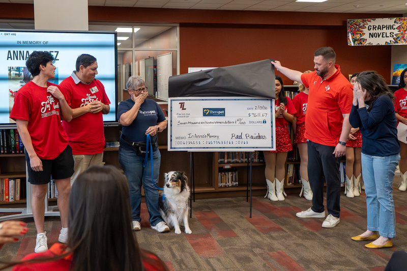 people presenting giant check
