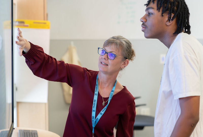 woman and teen boy looking at screen