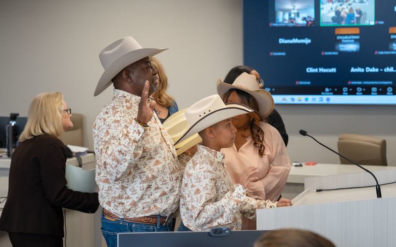 man and boy raise right hand in courtroom
