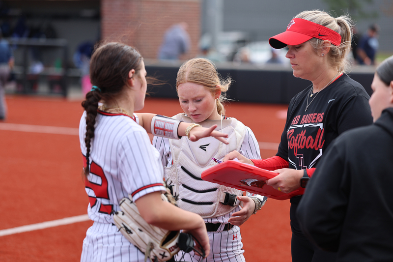 softball coach talking to her players on the field