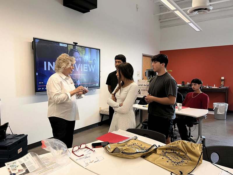 woman talking to teens in classroom