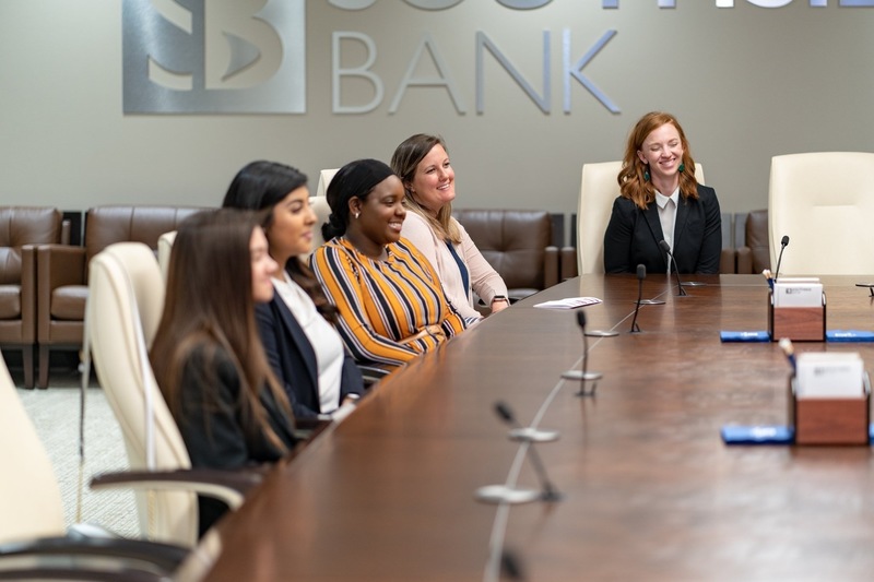 teen girls and woman sitting at board room table