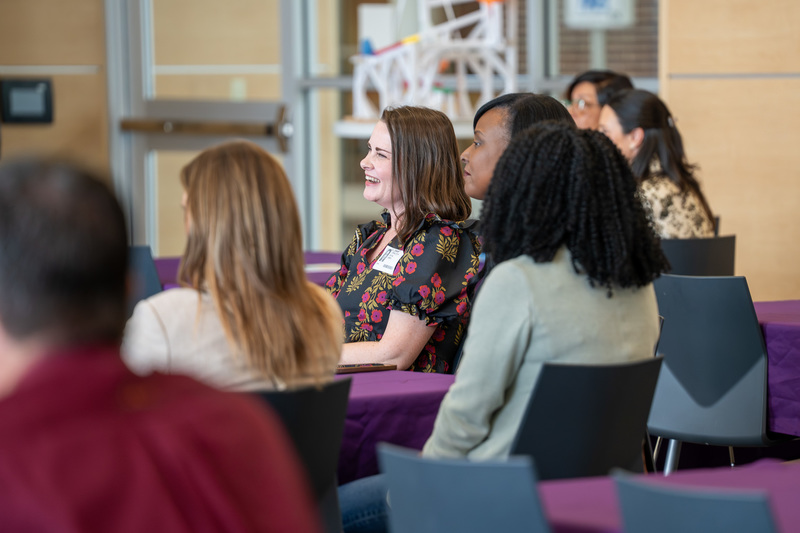 people in chairs listening to man talk