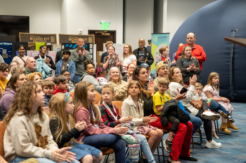 middle school kids in chairs clapping