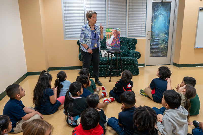 woman talking to kids sitting on the floor