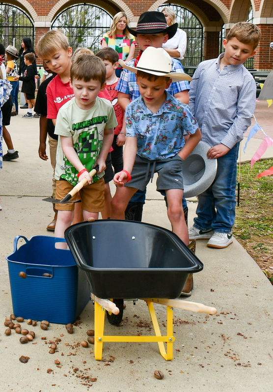 elementary students with wheelbarrow on sidewalk