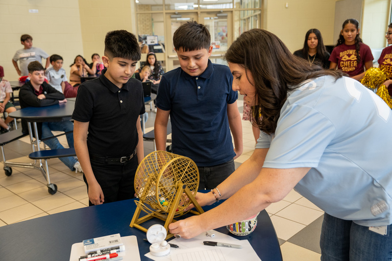 elementary age boys and woman spinning bingo wheel