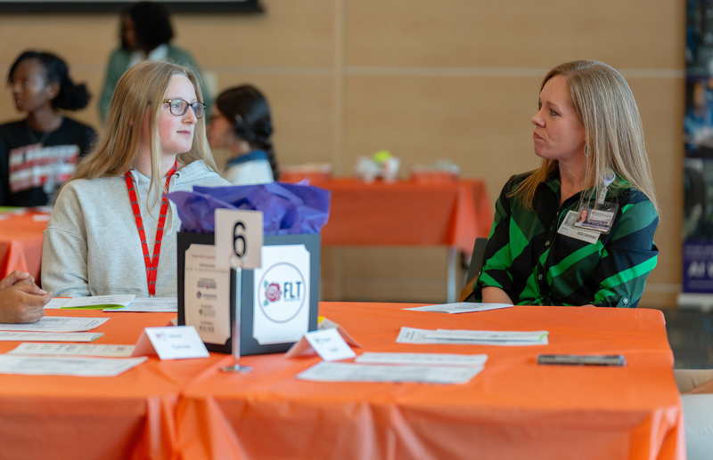 two women talking at a table