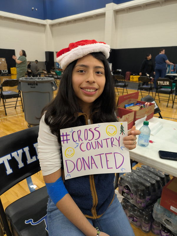 teen girl holding sign saying she donated blood