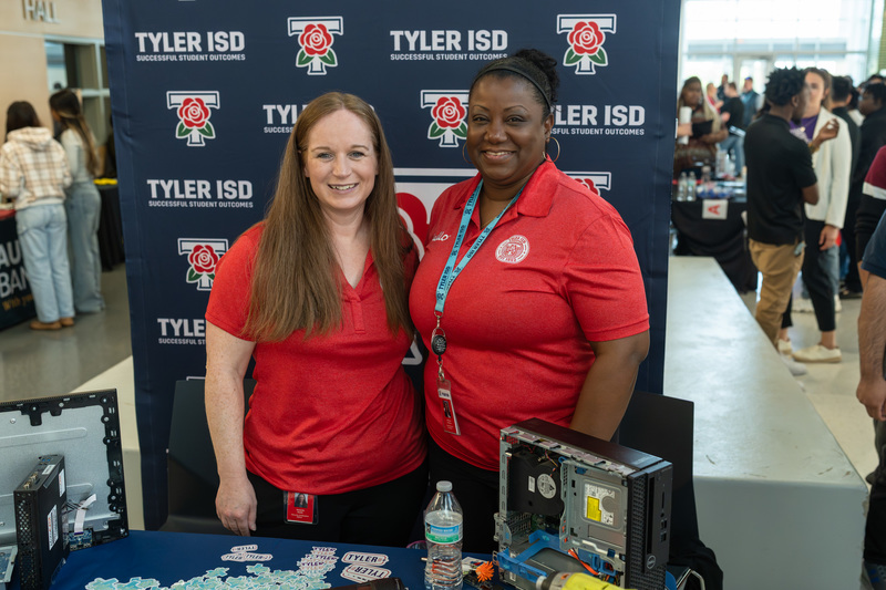 two women standing behind a table