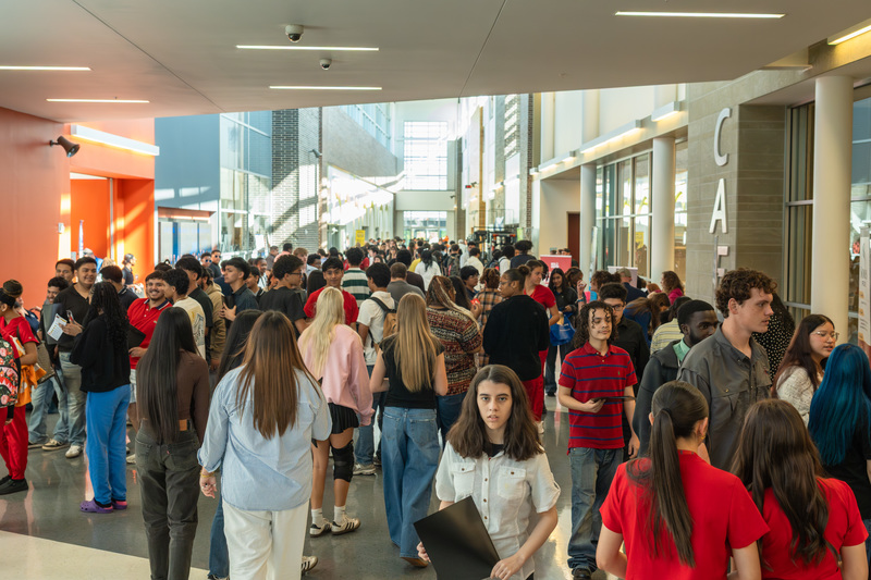 big group of teens walking down school hallway