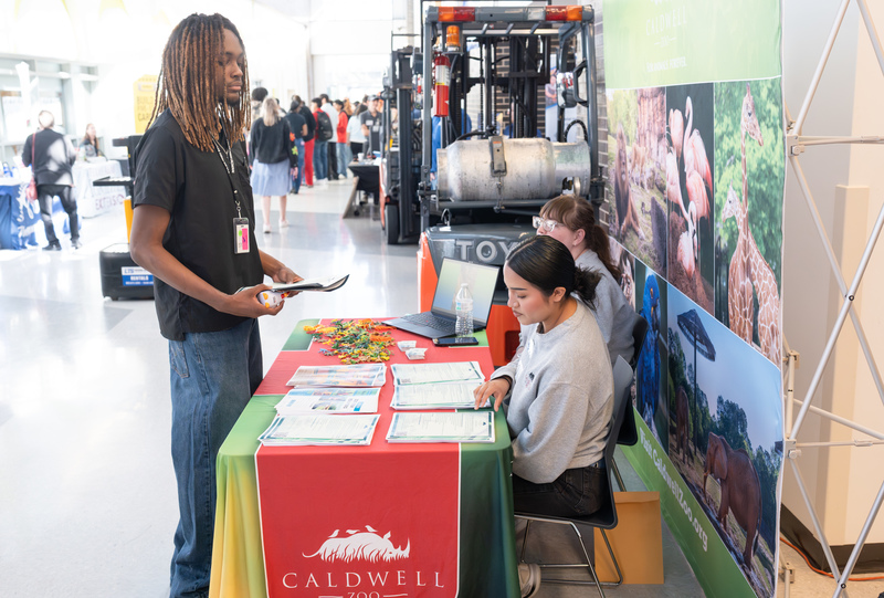 teen boy talking to women at a table