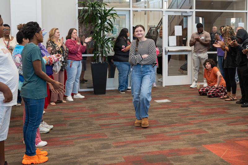 teen girl walking into library full of people