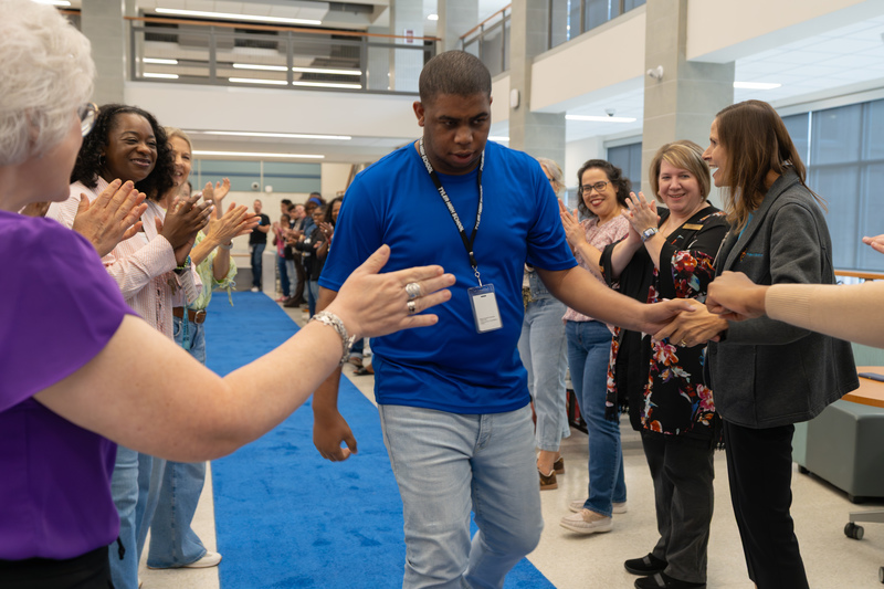 teen boy walking down blue carpet