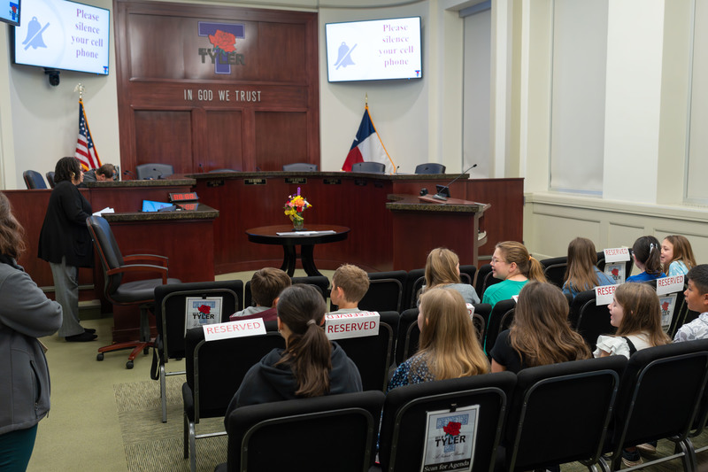 elementary age kids sitting in chairs in a courtroom