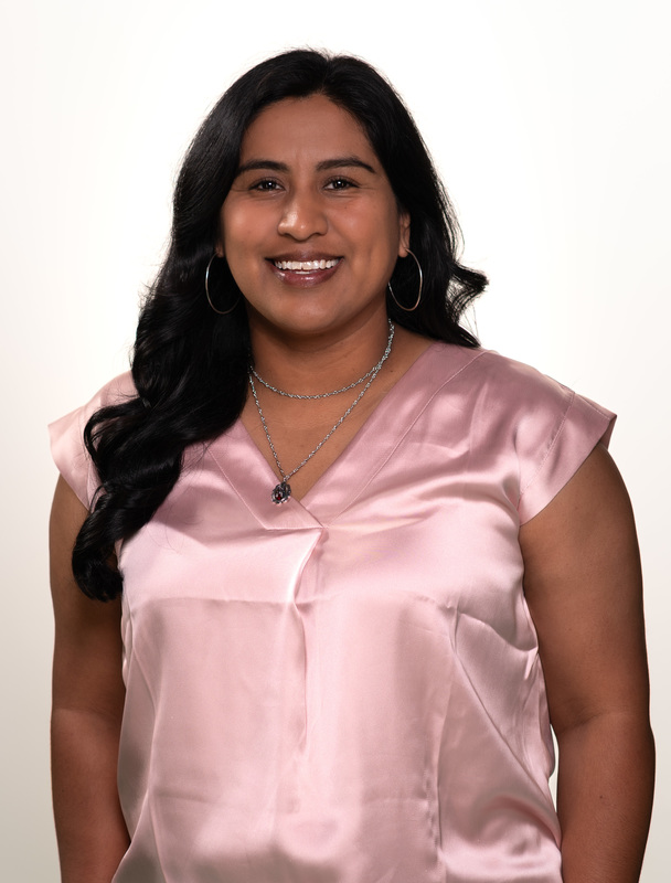 Hispanic woman in pink blouse smiling