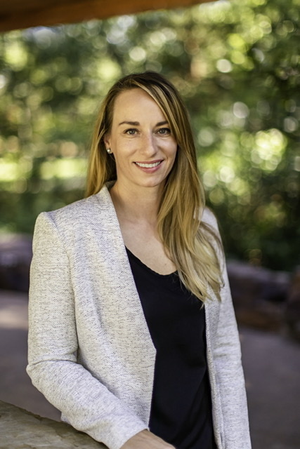 woman with long blonde/brown hair wearing jacket and black top