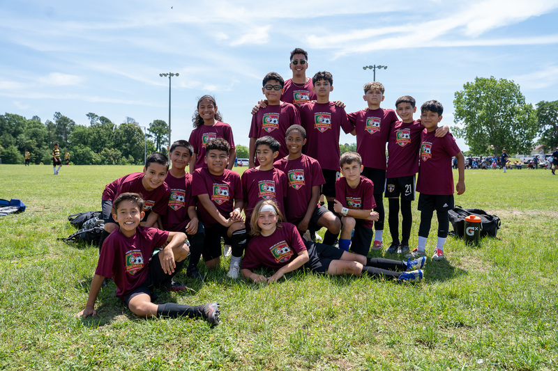 elementary kids in maroon soccer jerseys on field