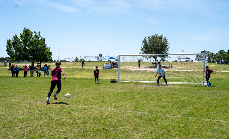 boy kicking ball toward soccer goal