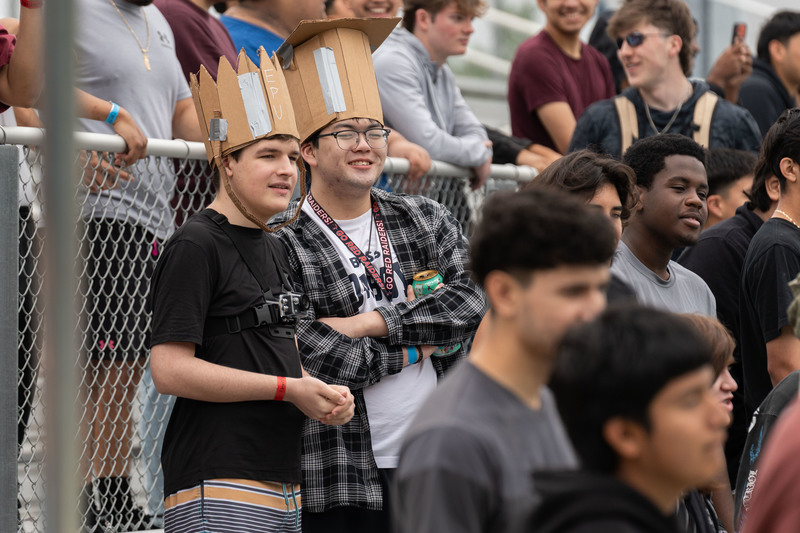 teens wearing cardboard crowns cheer in crowd
