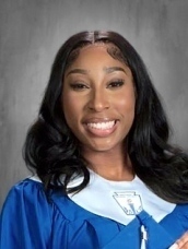 teen girl in blue graduation gown holding tassel from grad hat