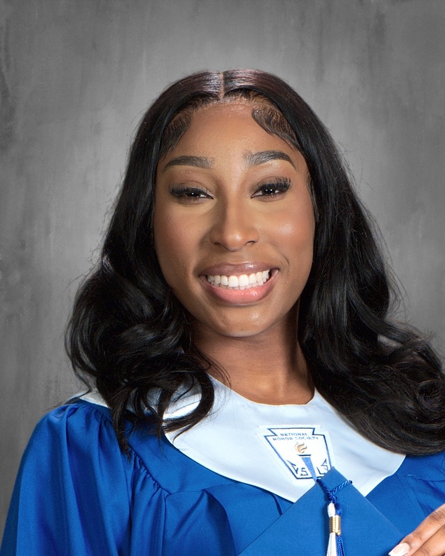 teen girl in blue graduation gown holding tassel from grad hat