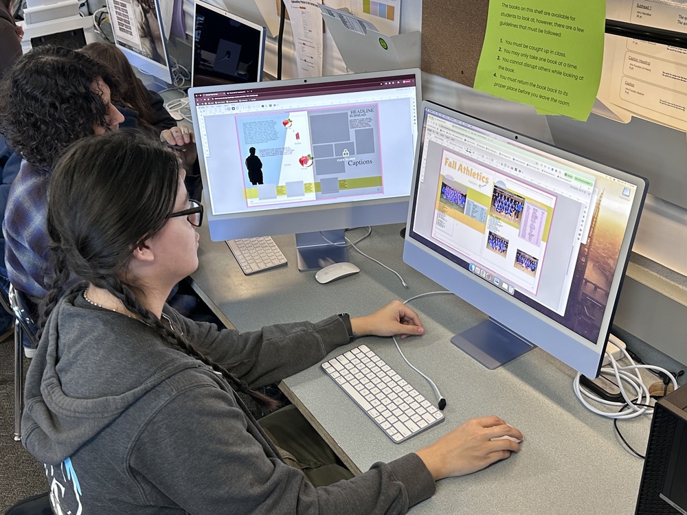 Yearbook students working on yearbook page