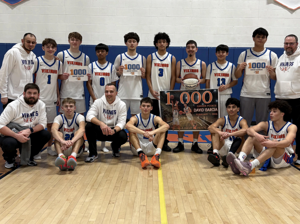 Photo courtesy of Umatilla Athletics Umatilla’s David Garcia (with ball) celebrates reaching 1,000 career points Feb. 7, 2026, with his coaches and teammates in Umatilla.